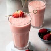 A strawberry is skewered on a glass.