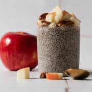 Chopped pieces of apple are around the base of the apple chia seed pudding.