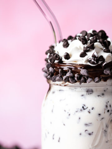 Whipped cream and chocolate chips are garnishing the chocolate chip milkshake.