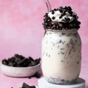 Whipped cream and chocolate chips are garnishing the milkshake in a mason jar.