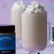 The almond milkshake is next to a jar of almond butter.