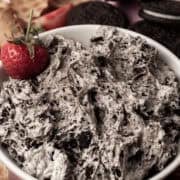 A strawberry is in a bowl with the Oreo dip.