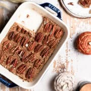 The no bake pecan pie bars are in a blue Staub casserole dish surrounded by pumpkins.