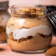 The pumpkin parfait is in a jar with the lid of the jar leaning against the jar.