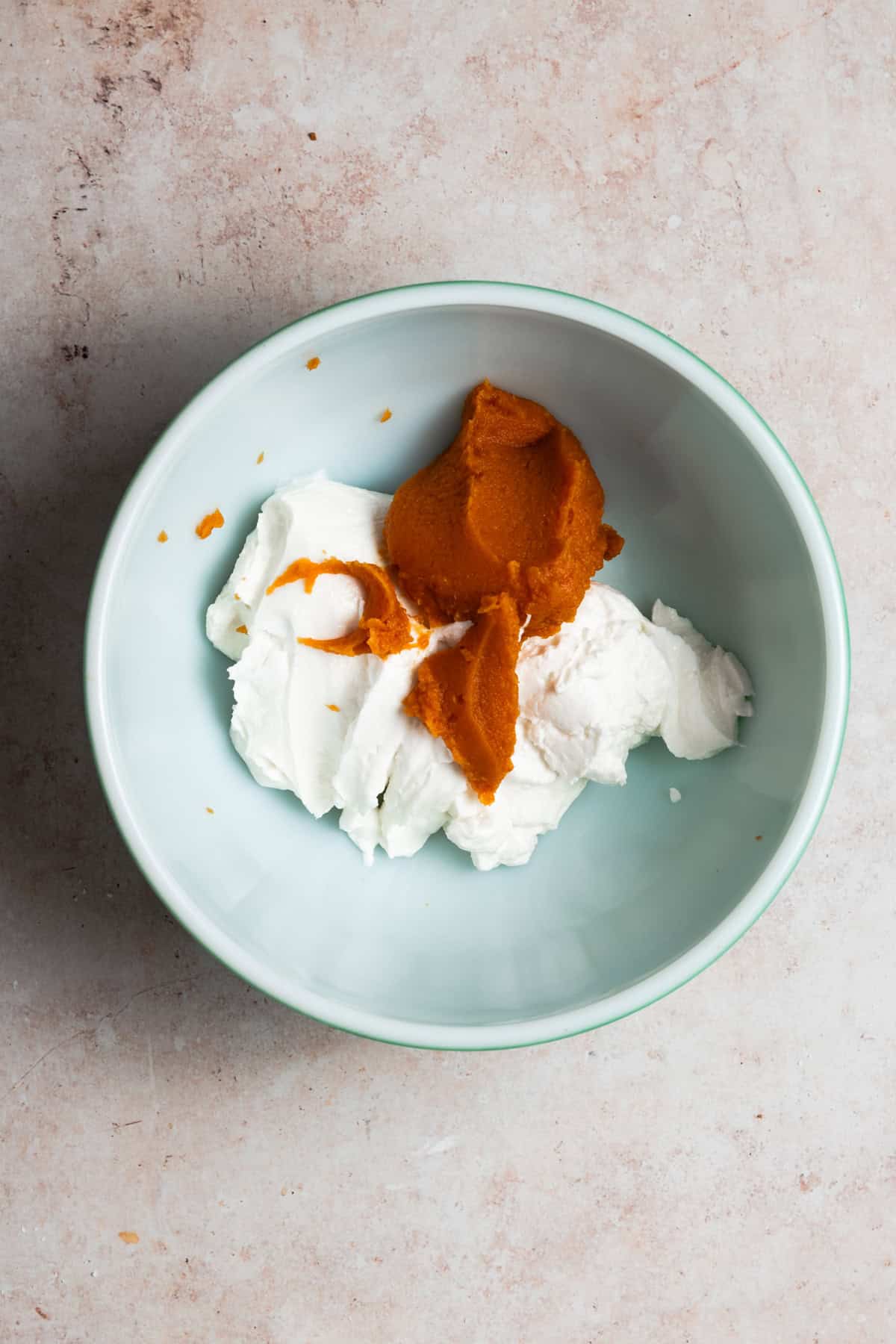 The pumpkin puree is added to the bowl.