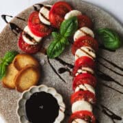 The candy cane caprese salad is drizzled with balsamic glaze.