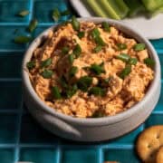 Scallions are chopped and sprinkled on top of the cold buffalo chicken dip.