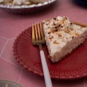 A fork is on a red plate with a slice of the no bake pina colada pie.
