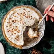 A spoon is in the pan of no bake coconut cream pie.