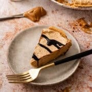 A fork is on a plate with a slice of the no bake peanut butter pie.