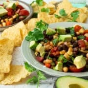 The bowl of cowboy caviar is surrounded by tortilla chips.