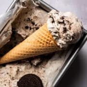 An ice cream cone with the no churn oreo ice cream is in a loaf pan.