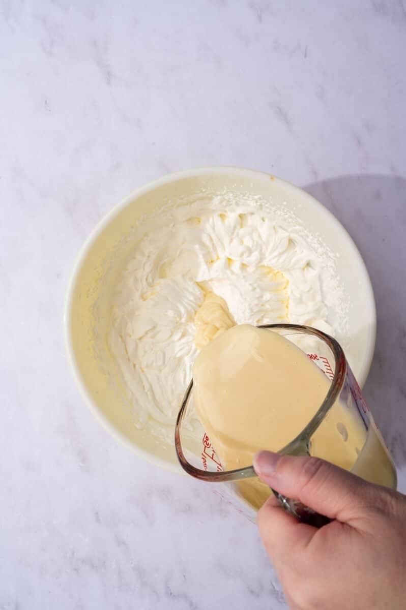 The sweetened condensed milk and whipped cream are mixed together.