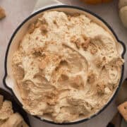 The pumpkin pie dip is a in a white skillet topped with graham cracker crumbs.
