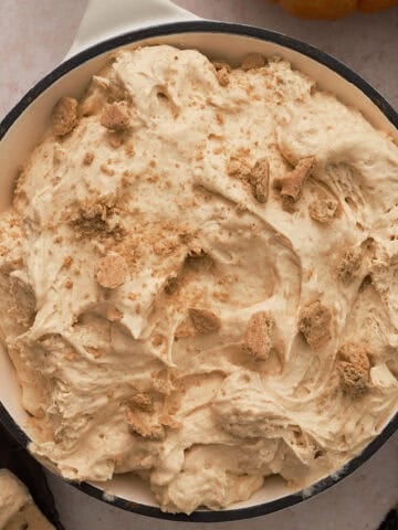 The pumpkin pie dip is a in a white skillet topped with graham cracker crumbs.