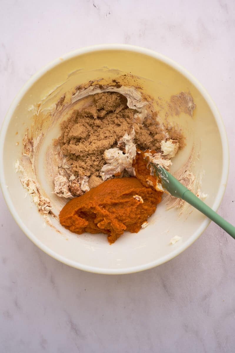The pumpkin, cream cheese, and brown sugar are in a large bowl.