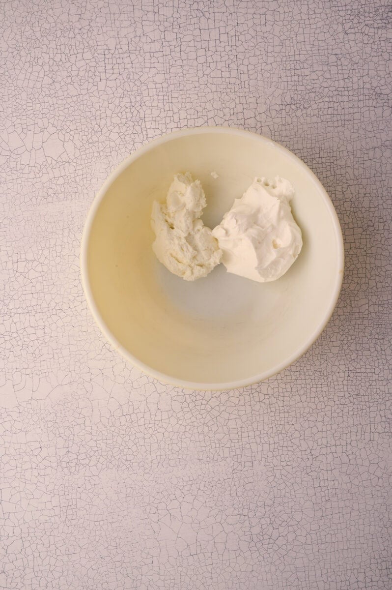 The sour cream is added to a bowl.