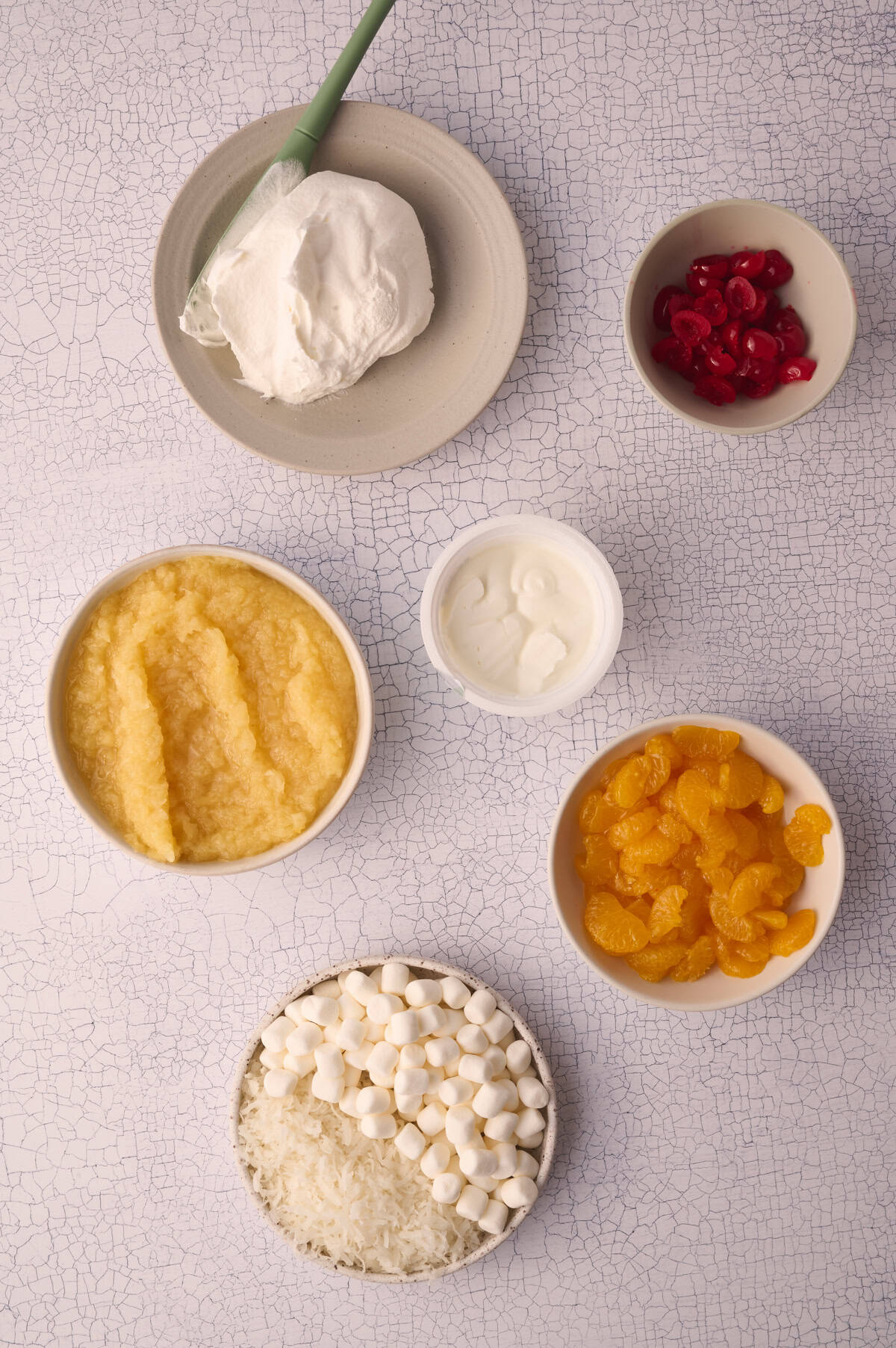 The ingredients for the ambrosia salad are laid out in dishes.