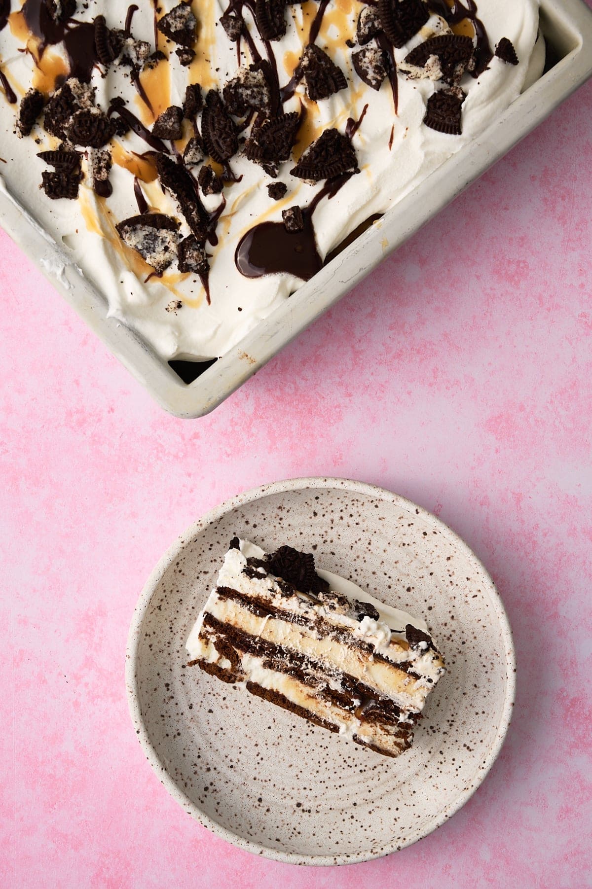 A slice of the cake is on a plate with the rest of the cake next to it.