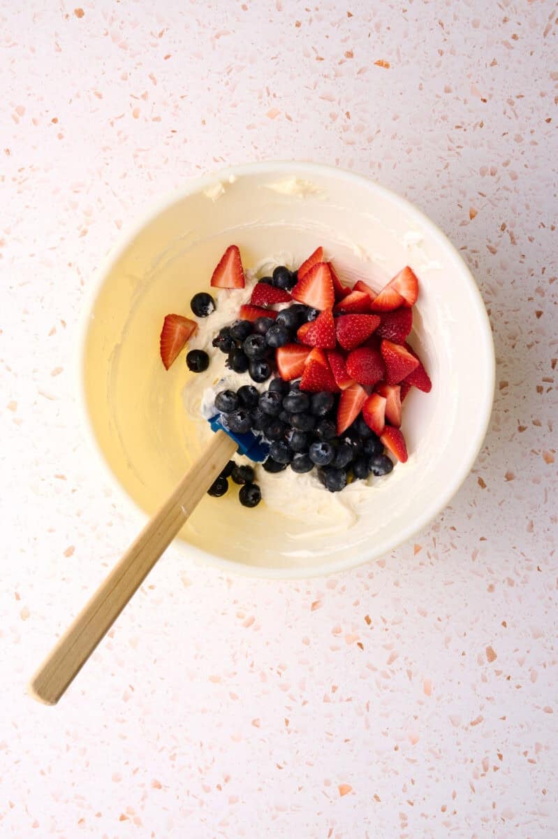 The fruit is added to the bowl with the cream cheese mixture.