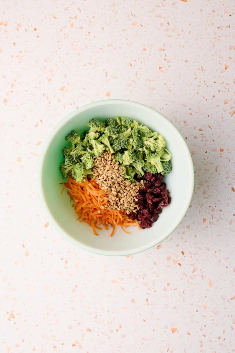 The ingredients for the broccoli crunch salad are in a bowl.
