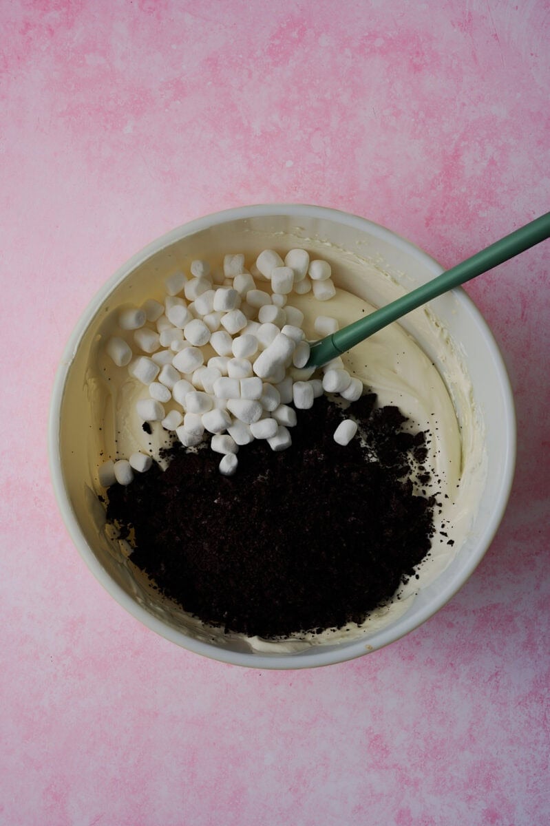 The crushed oreos and mini marshmallows are added to the bowl.