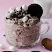 The oreo fluff is in a glass mug topped with marshmallows and oreos.